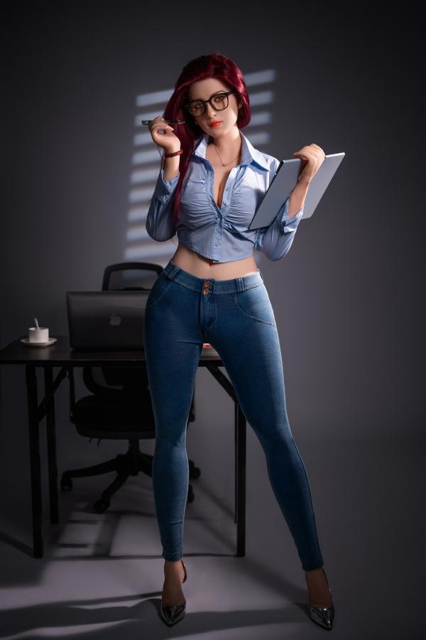 Bubbly 169cm curvy D-cup hybrid sex doll standing by an office desk in an open denim shirt, jeans, heels and glasses